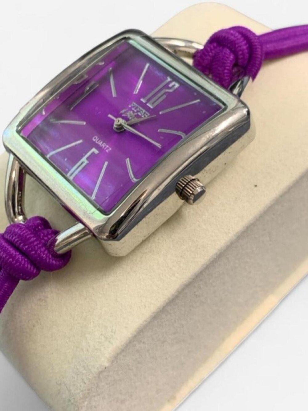 Bracelet watch featuring a square/diamond-oriented stainless steel case with a v
